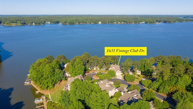 drone / aerial view featuring a view of trees and a water view