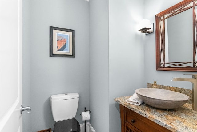 bathroom featuring baseboards, toilet, and vanity