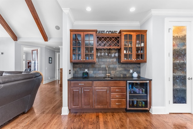 bar with beverage cooler, wet bar, tasteful backsplash, and a sink