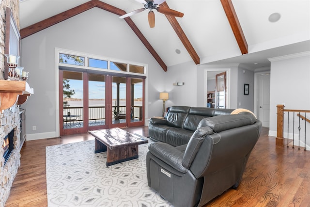 living area with beamed ceiling, wood finished floors, and a ceiling fan