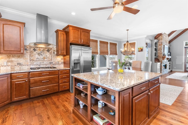 kitchen with stainless steel refrigerator with ice dispenser, open shelves, wood finished floors, gas stovetop, and wall chimney range hood