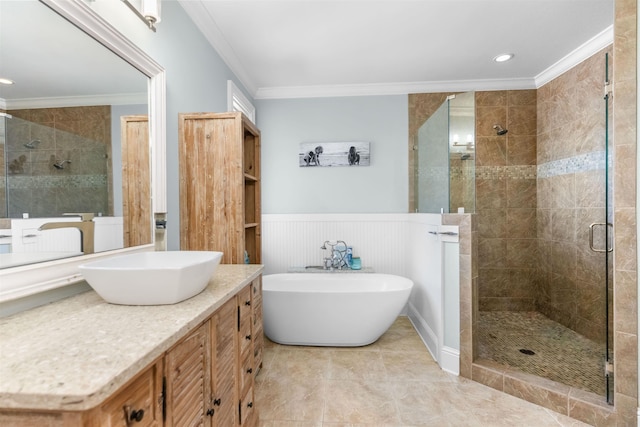 full bathroom with crown molding, a wainscoted wall, a stall shower, a freestanding tub, and vanity