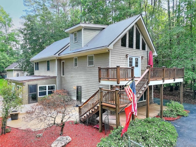 243 Riverbend Dr, Eatonton, GA 31024 - back of house with stairway, a patio area, a wooden deck, and a metal roof