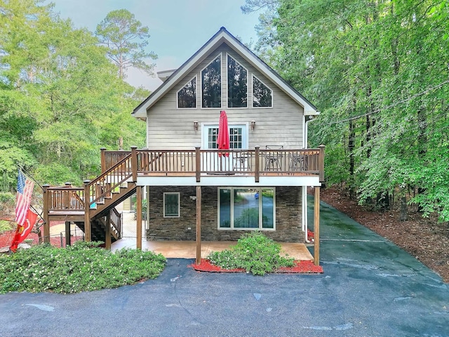 243 Riverbend Dr, Eatonton, GA 31024 - view of front of home featuring stone siding, a wooden deck, stairs, and a patio area
