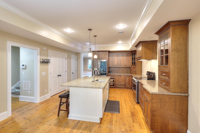 243 Riverbend Dr, Eatonton, GA 31024 - kitchen featuring appliances with stainless steel finishes, brown cabinetry, light wood-style floors, crown molding, and recessed lighting