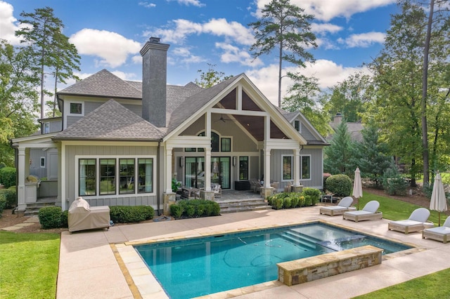 back of house featuring a pool with hot tub and a patio area