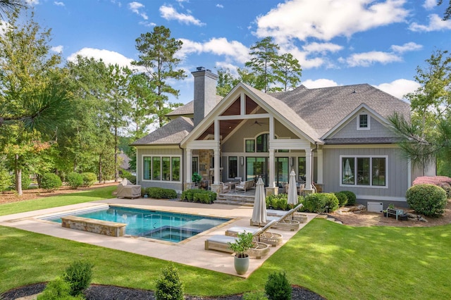 back of house with an outdoor living space, a yard, ceiling fan, a swimming pool with hot tub, and a patio