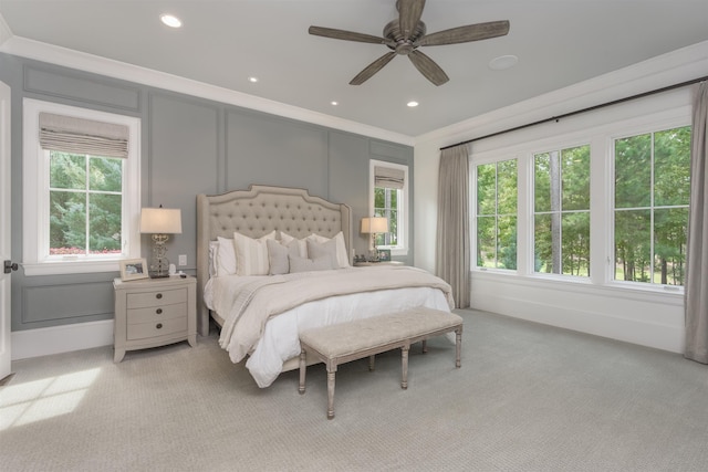 bedroom with ceiling fan, light colored carpet, and crown molding