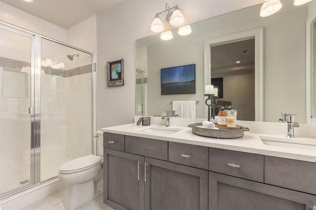 bathroom featuring vanity, toilet, tile patterned floors, and a shower with shower door