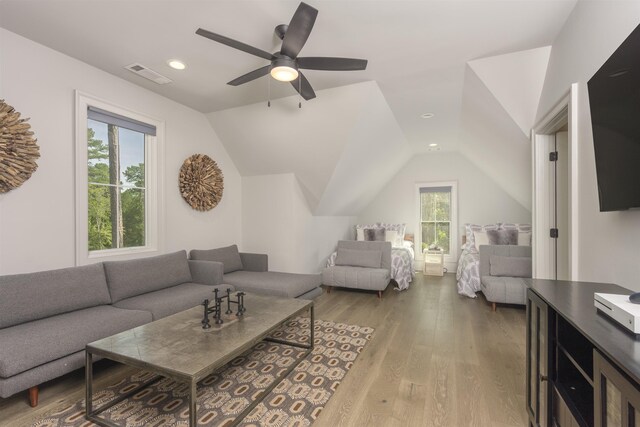 living room featuring hardwood / wood-style flooring, ceiling fan, and vaulted ceiling