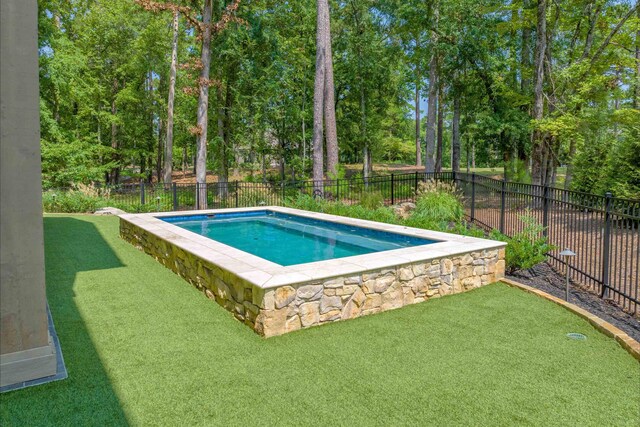 view of swimming pool featuring a yard