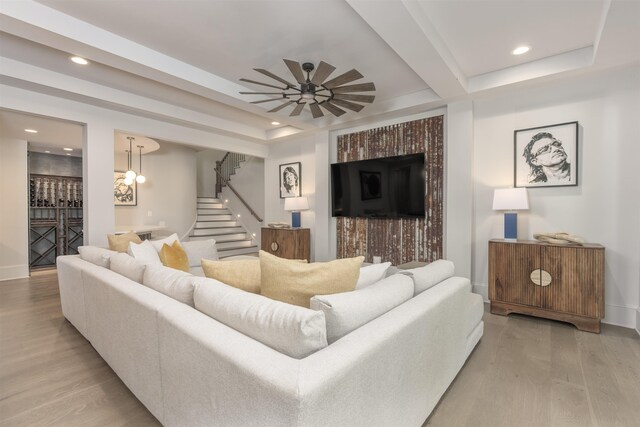 living room with light hardwood / wood-style flooring, beamed ceiling, and ceiling fan