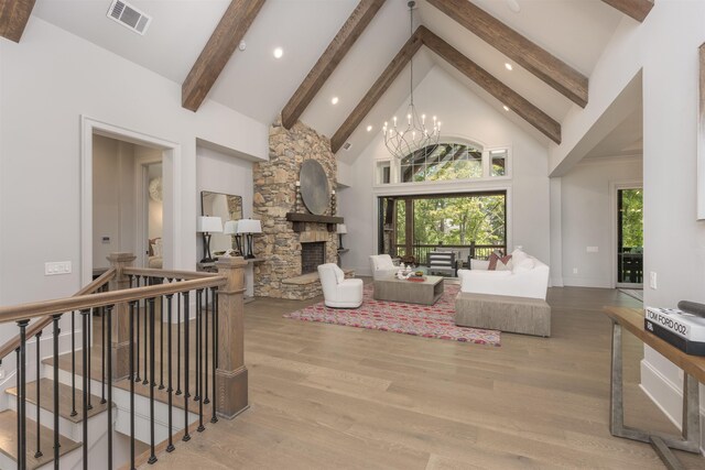 living room featuring a fireplace, high vaulted ceiling, beamed ceiling, a chandelier, and light wood-type flooring