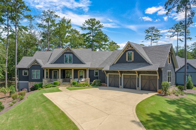 craftsman inspired home featuring a garage, covered porch, and a front yard