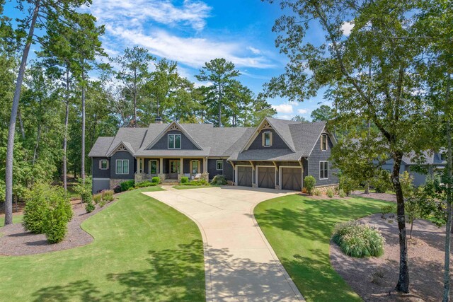 craftsman inspired home with a porch, a garage, and a front lawn