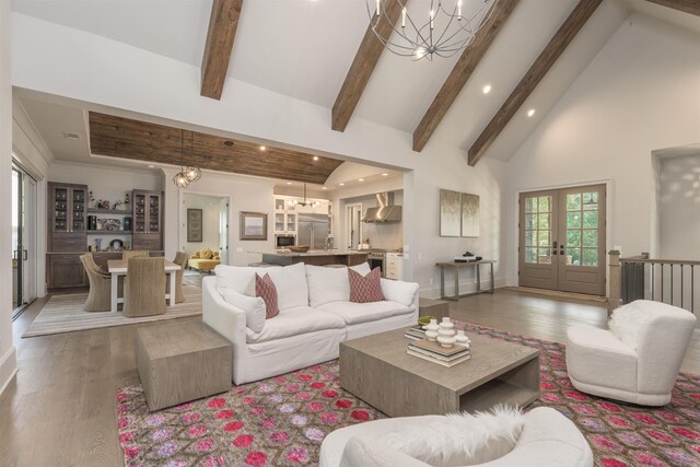 living room with an inviting chandelier, light hardwood / wood-style flooring, high vaulted ceiling, and beamed ceiling