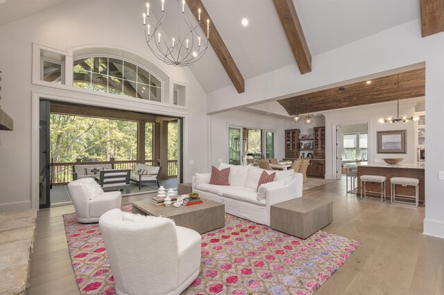 living room with beam ceiling, high vaulted ceiling, light hardwood / wood-style floors, and a chandelier