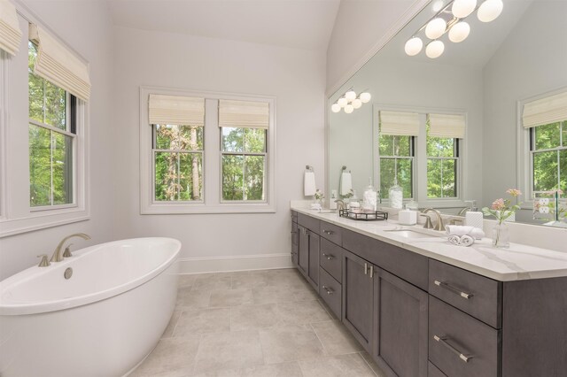 bathroom featuring vanity, a bathtub, and lofted ceiling