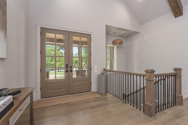 entryway featuring lofted ceiling with beams, hardwood / wood-style floors, and french doors