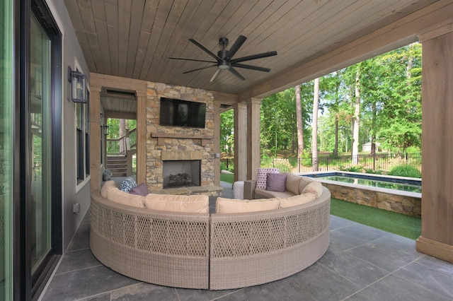 view of patio with an outdoor living space with a fireplace and ceiling fan