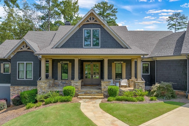 craftsman inspired home with french doors, covered porch, and a front lawn