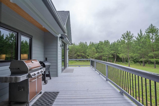 wooden deck with area for grilling and a lawn