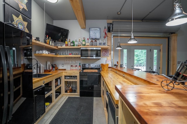 kitchen with decorative light fixtures, butcher block counters, sink, and black appliances