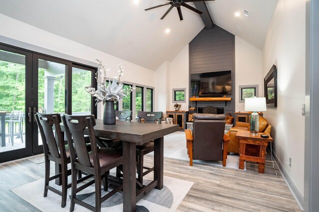 dining area with ceiling fan, beam ceiling, high vaulted ceiling, light hardwood / wood-style floors, and french doors