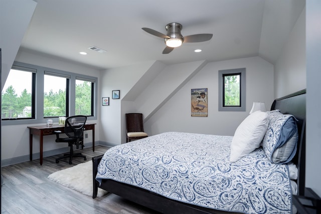 bedroom with ceiling fan, lofted ceiling, and light wood-type flooring