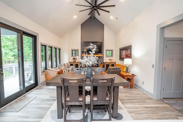 dining space featuring beamed ceiling, high vaulted ceiling, and light hardwood / wood-style flooring