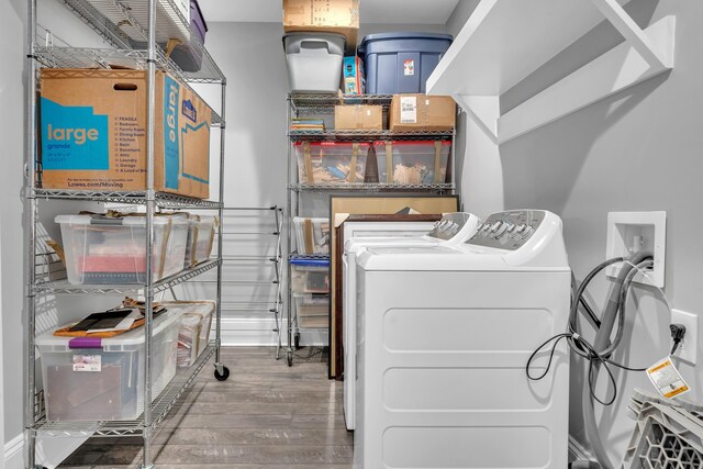 clothes washing area with hardwood / wood-style flooring and separate washer and dryer