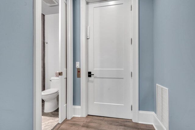 interior space featuring wood-type flooring and toilet