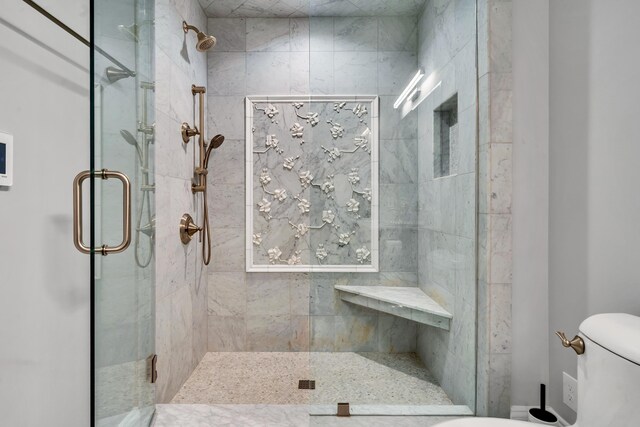 bathroom featuring toilet and a shower with shower door