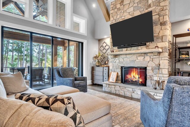 living room with hardwood / wood-style flooring, a fireplace, and a high ceiling