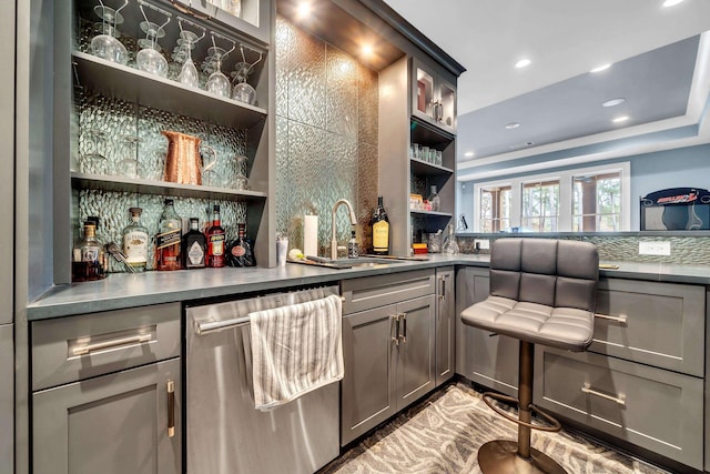 bar with gray cabinets, sink, and stainless steel dishwasher