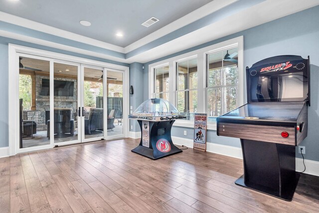 rec room with hardwood / wood-style floors and a tray ceiling