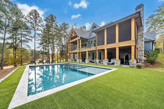 back of house with a sunroom, a yard, and a patio area