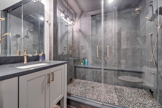 bathroom featuring walk in shower and vanity