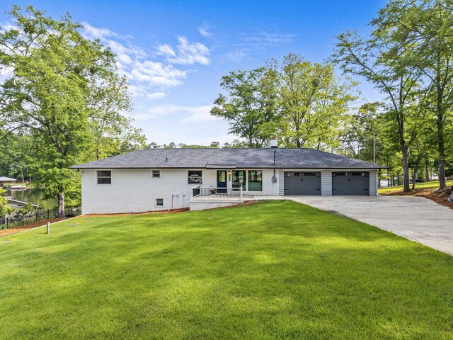 307 Lakeview Dr, Milledgeville, GA 31061 - back of property with a garage, a yard, driveway, and covered porch
