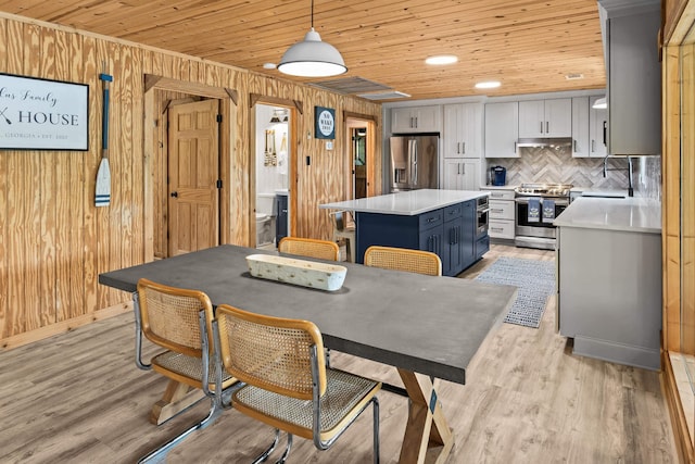 dining room with light wood-style floors, wood walls, and wood ceiling