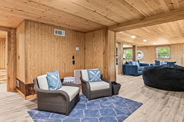 living area with wooden walls, wood ceiling, wood finished floors, and visible vents