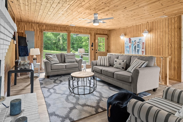 living room with wood walls, wood ceiling, ceiling fan, and wood finished floors