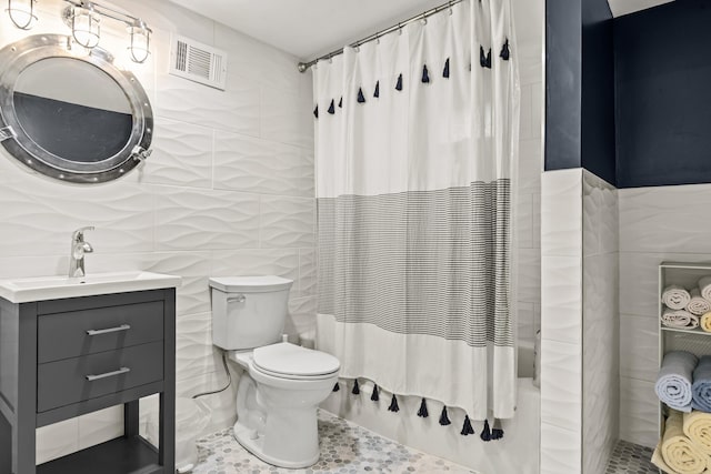 full bath with tile walls, shower / bath combination with curtain, toilet, and visible vents
