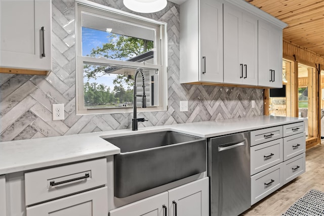 kitchen featuring wood ceiling, backsplash, dishwasher, a sink, and white cabinetry