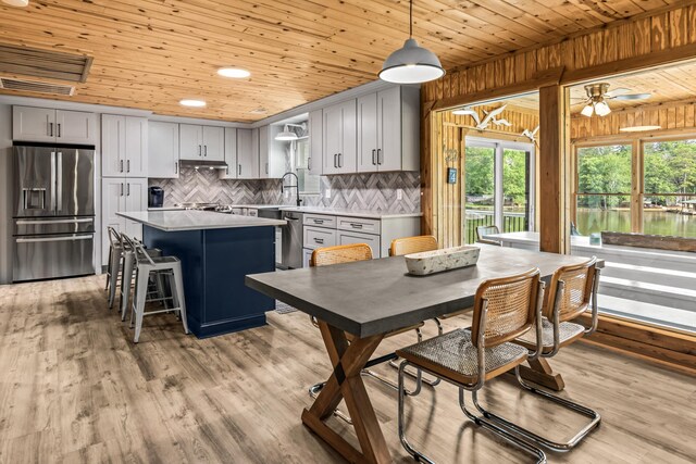 307 Lakeview Dr, Milledgeville, GA 31061 - kitchen with appliances with stainless steel finishes, wooden ceiling, light countertops, decorative backsplash, and a center island