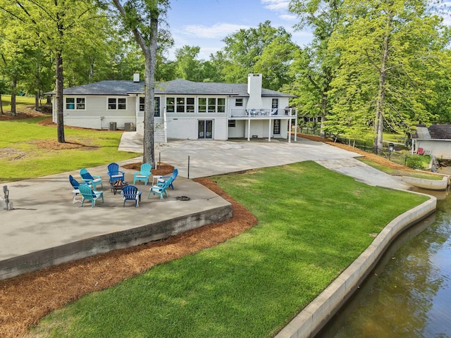 back of property featuring a patio, a lawn, and a chimney