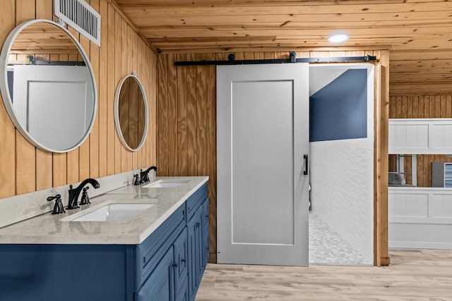 full bath featuring wood ceiling, wood walls, visible vents, and a sink