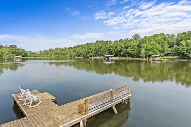 dock area featuring a water view and a wooded view