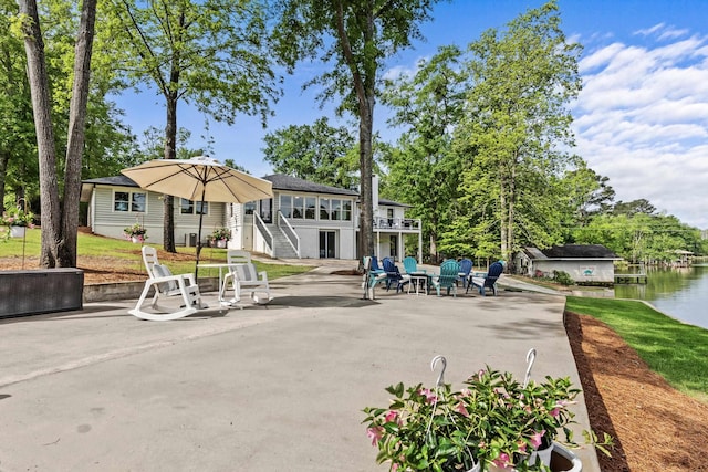view of home's community featuring a water view, a patio area, and stairway
