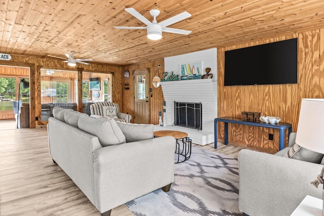 living room with wooden walls, ceiling fan, wood ceiling, and a fireplace